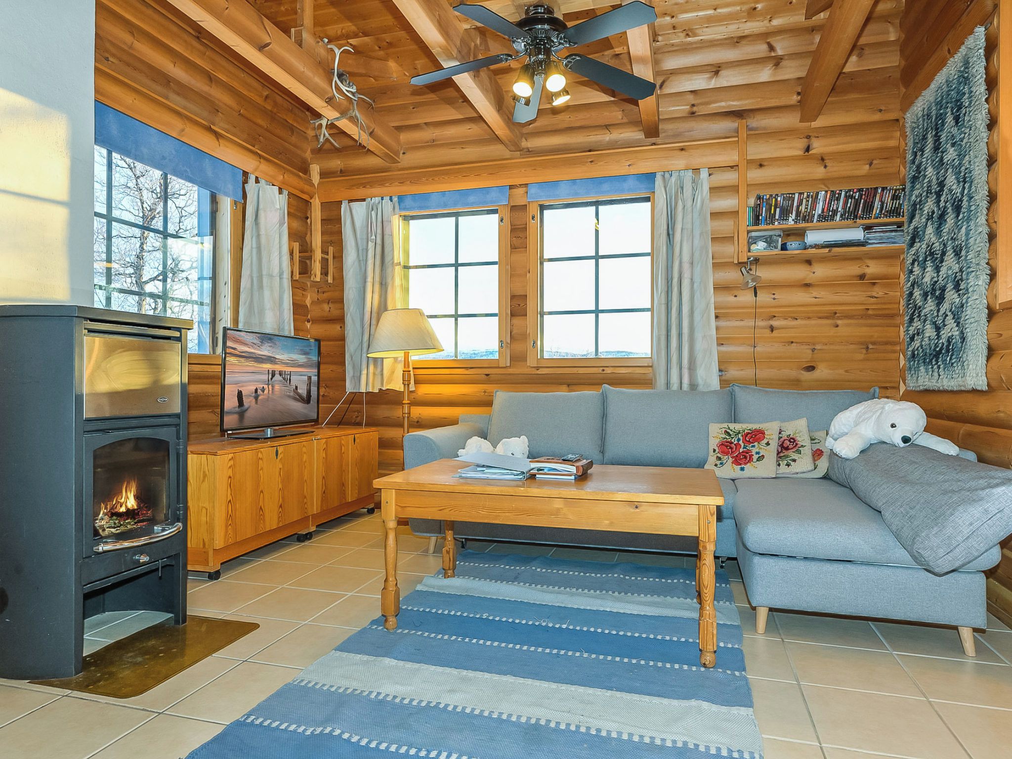L’intérieur d’un chalet accueillant, avec une cheminée, un canapé, une table basse et un téléviseur.