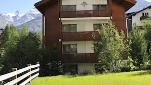 A two-story building with a wooden facade, balconies, and a mountain backdrop. - Amasaas by Interhome (Saas-Fee)