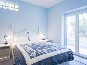 A bedroom with a bed, bedside tables, and a window. - Waterfront Oasis by Interhome (Ston)