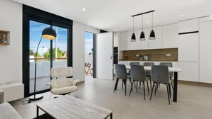 Un appartement moderne doté d’un coin repas, d’un canapé et d’une grande fenêtre.