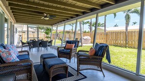 A covered patio with wicker furniture and a view of a fenced yard. - 5027 Fairfield Dr - Paradise Palms 3 Bedroom Home by RedAwning (Fort Myers)