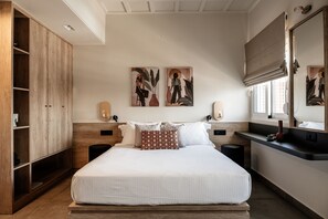 Un dormitorio moderno con una cama grande, un armario de madera, mesitas de noche, decoración en la pared y un espejo.