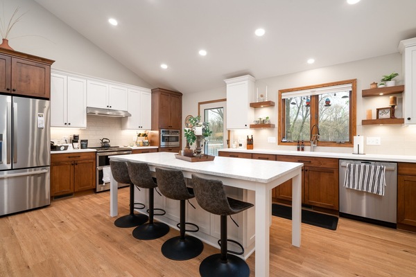 Your gourmet kitchen awaits with premium appliances, spacious island seating for four, and warm wood finishes perfect for cooking memorable meals together.