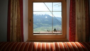 Una habitación con ventana que da a un paisaje montañoso.