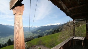 Un balcón de madera con vistas a un paisaje montañoso.