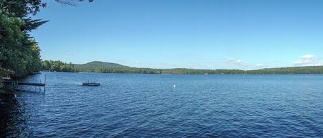 A calm lake with a dock and a small boat.