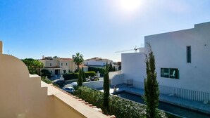 Un quartier résidentiel avec des bâtiments modernes, un ciel dégagé et un soleil éclatant.
