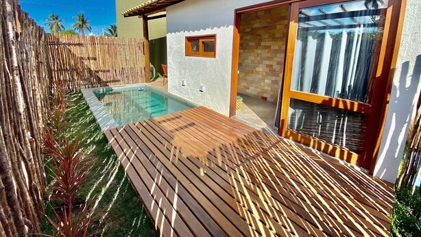A modern house with a swimming pool, wooden deck, and a large glass door. - Jubaia Milagres by ER (São Miguel dos Milagres)