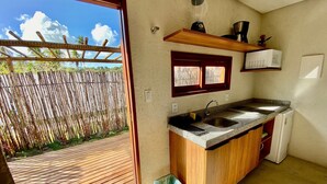 A compact kitchen with a built-in sink, a wooden countertop, and a small refrigerator. - Jubaia Milagres by ER (São Miguel dos Milagres)