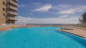 A swimming pool with lounge chairs and a view of the ocean. - 1bd/2ba Unit w/ a Bunk Alcove and Amazing Views Right on the Gulf! (Panama City Beach)