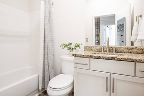 Bathtub, hair dryer, towels, shampoo