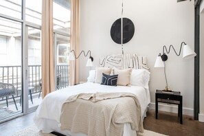 Une chambre à coucher avec un grand lit, un élément de décoration circulaire au mur, deux lampes de chevet et une petite table d’appoint.