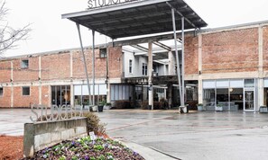 A building with a covered entrance, a sign reading "STUDIO G-9", and a parking area with a sign indicating no pets allowed.