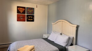 A bedroom with a bed, a nightstand, and a ceiling fan. - Riverview charming apt near beach (Ipswich)