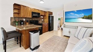 Una cucina moderna con mobili in legno, un forno a microonde integrato e un frigorifero.