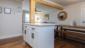 A kitchen with white cabinetry, a wooden bench, and a herringbone-patterned floor. - Beach Vibe with Hot tub! 10 min walk to the Beach! Amazing Backyard! (Virginia Beach)