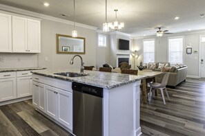 Enjoy meals in the spacious kitchen with a central island and dishwasher, surrounded by a seating area with a sofa and chairs.