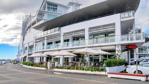 Ein modernes Gebäude mit mehreren Ebenen, Außenplätzen und einem überdachten Bereich.
