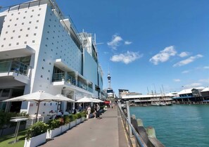 A waterfront hotel with outdoor seating and a view of the water. - Waterfront Seaview Apt Hotel (Auckland)