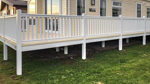 Una casa móvil con terraza blanca y un letrero que dice 'WILLIERY'.