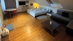 A compact living space with a bed, sofa, and a dining area. - İstanbul Apartment (Belgrade)