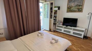 Une chambre d’hôtel avec un lit, une télévision, une bibliothèque et un tableau au mur.