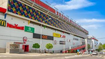 Uno stadio con diversi cartelloni pubblicitari, tra cui McDonald's, New Yorker e CCC.