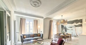 A living room with a sofa, coffee table, and dining area. - N&J – SEAHORSE – Central – Very close sea (Niza)