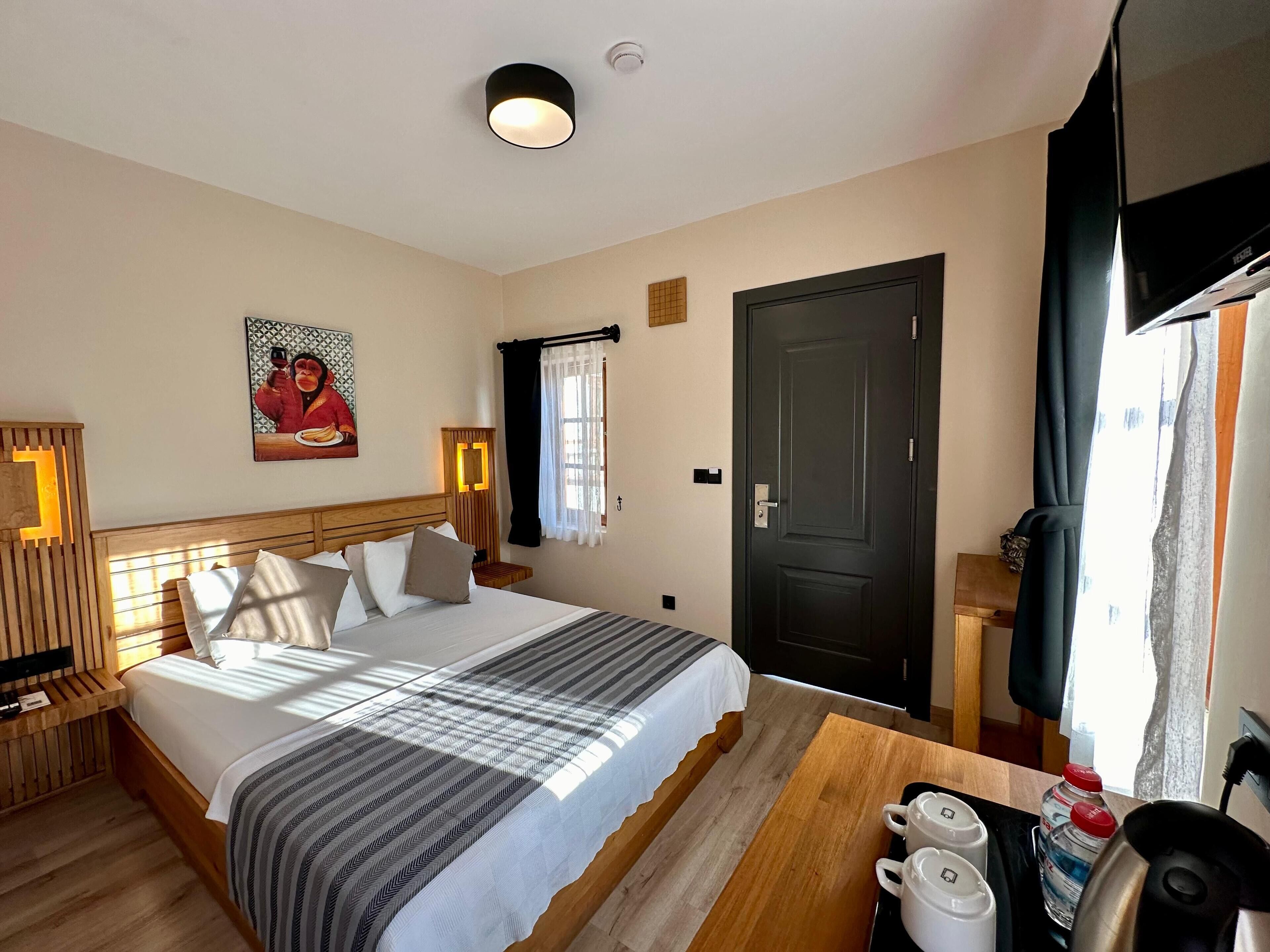 Una habitación de hotel con cama, mesita de noche y televisión.
