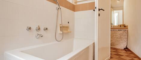 Ein Badezimmer mit einer Badewanne, einer Dusche und einem WC.