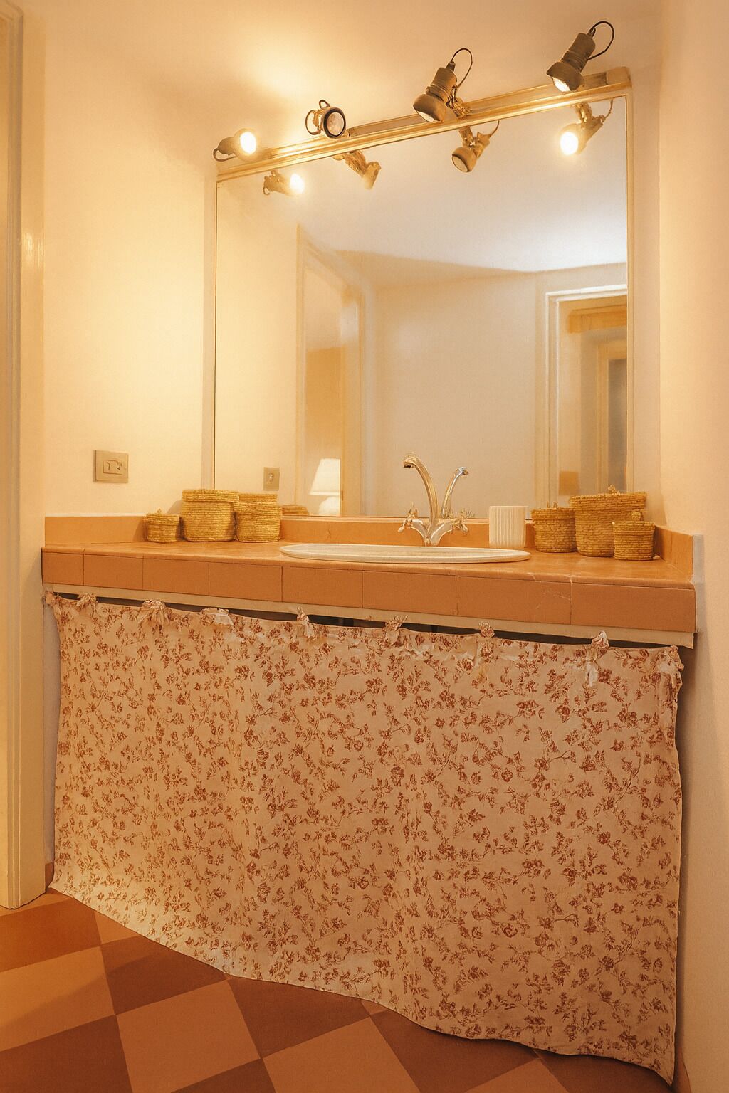 A bathroom with a large mirror, a sink, and a towel rack.