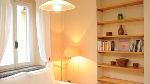 A room with a white sofa, a bookshelf, and a lamp. - Ivy house  (Milan)