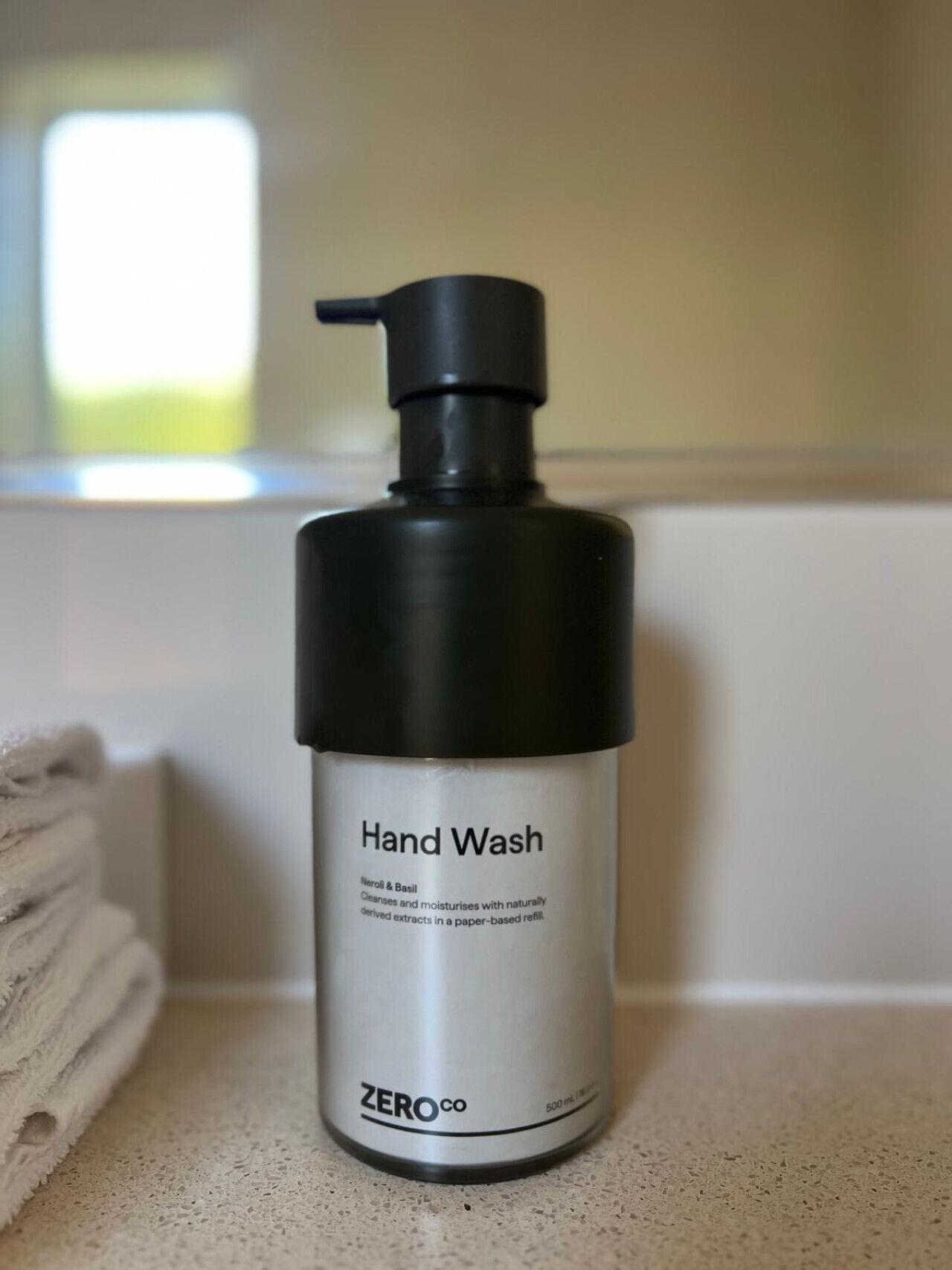 A hand wash bottle labeled "Hand Wash" with a pump dispenser, placed on a countertop.