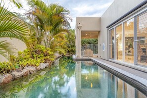 Relax beside the resort style private pool (it even has a fountain and lights that change colour) with a complimentary glass of wine. - Walk to Golf Course, Lagoon Pool, Coastal Lux Home (Pelican Waters)