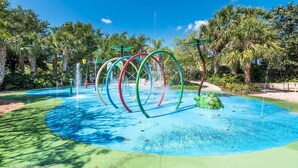 A water play area with colorful rings and a central water feature surrounded by palm trees. - Bahama Bay - Minutes from Disney Theme Parks! (Davenport)