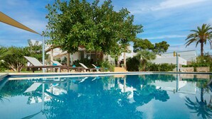 A swimming pool with lounge chairs and a tree in the background. - Villa Punta des Port 13 by dracmallorca (Porto Petro)