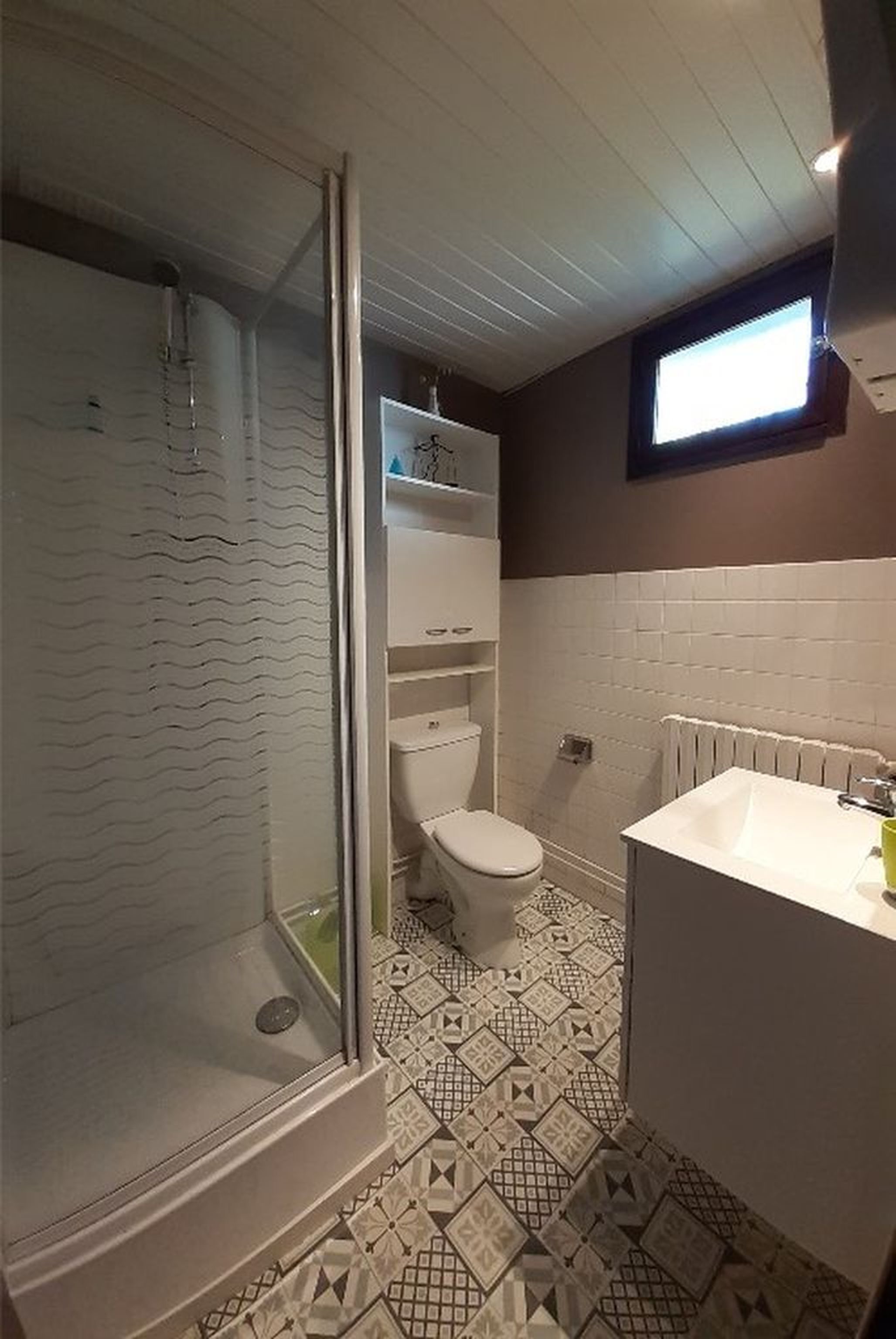 A bathroom with a shower, toilet, and sink.