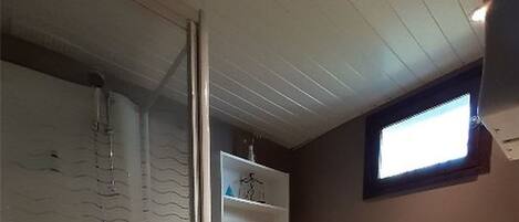A bathroom with a shower, toilet, and sink.