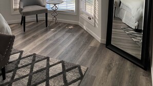 Une chambre avec un grand miroir, une chaise et une petite table.