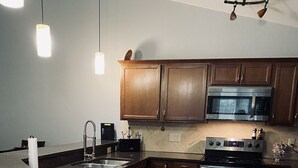 Une cuisine moderne avec des meubles en bois, des appareils en acier inoxydable et un plan de travail en granit.