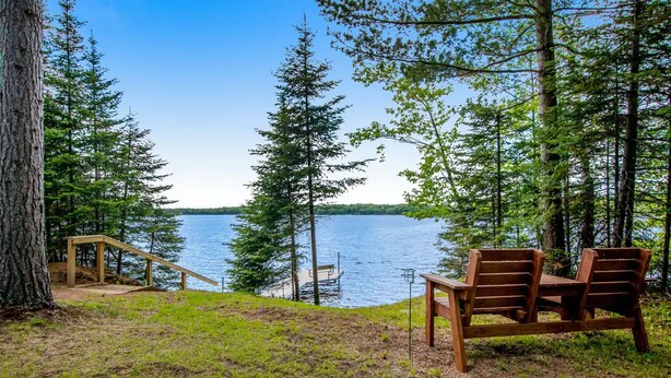 A lakeside view with a wooden bench and a small wooden staircase leading to a dock. - Lured Den - Private Lakefront Cottage - HOT TUB! (Conover)
