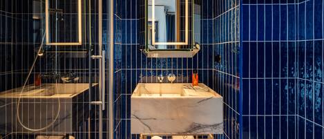 A bathroom with a marble sink, a mirror, and a towel rack.