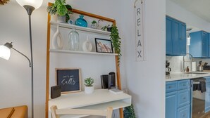 Eine moderne Küche mit blauen Schränken, einer weißen Arbeitsplatte und einem Regal mit Dekoration.