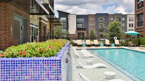 Une piscine avec des chaises longues et une allée dallée.