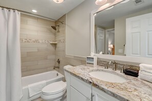 Un baño moderno con bañera, inodoro y lavamanos.