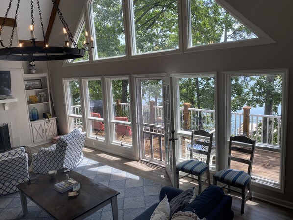 A spacious room with large windows, a ceiling fan, and a view of the outdoors.