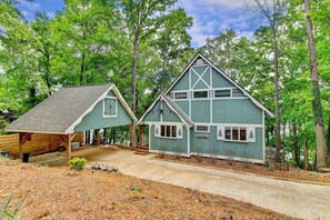 A two-story house with a steep gable roof, a front porch, and a driveway leading to the entrance.