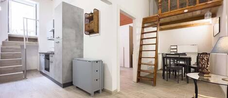 Una cocina amplia con horno empotrado, refrigerador y comedor con mesa y sillas.