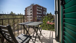 A balcony with a table and chairs, overlooking a building with multiple balconies. - CASA SAINA - Studio Limone (Rovinj)