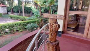 A reception sign on a wooden post with a metal railing in the foreground. - Ngorongoro Corridor Lodge (Karatu)